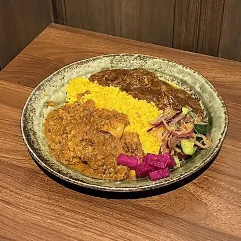 2種類のカレーをターメリックライスの両側にかけた2種盛カレー。アチャールと漬物添え
