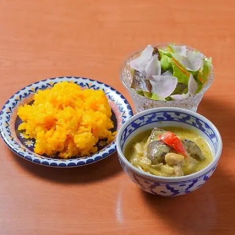 小鉢に盛られたグリーンカレー。ターメリックライスとサラダを別皿で添えて